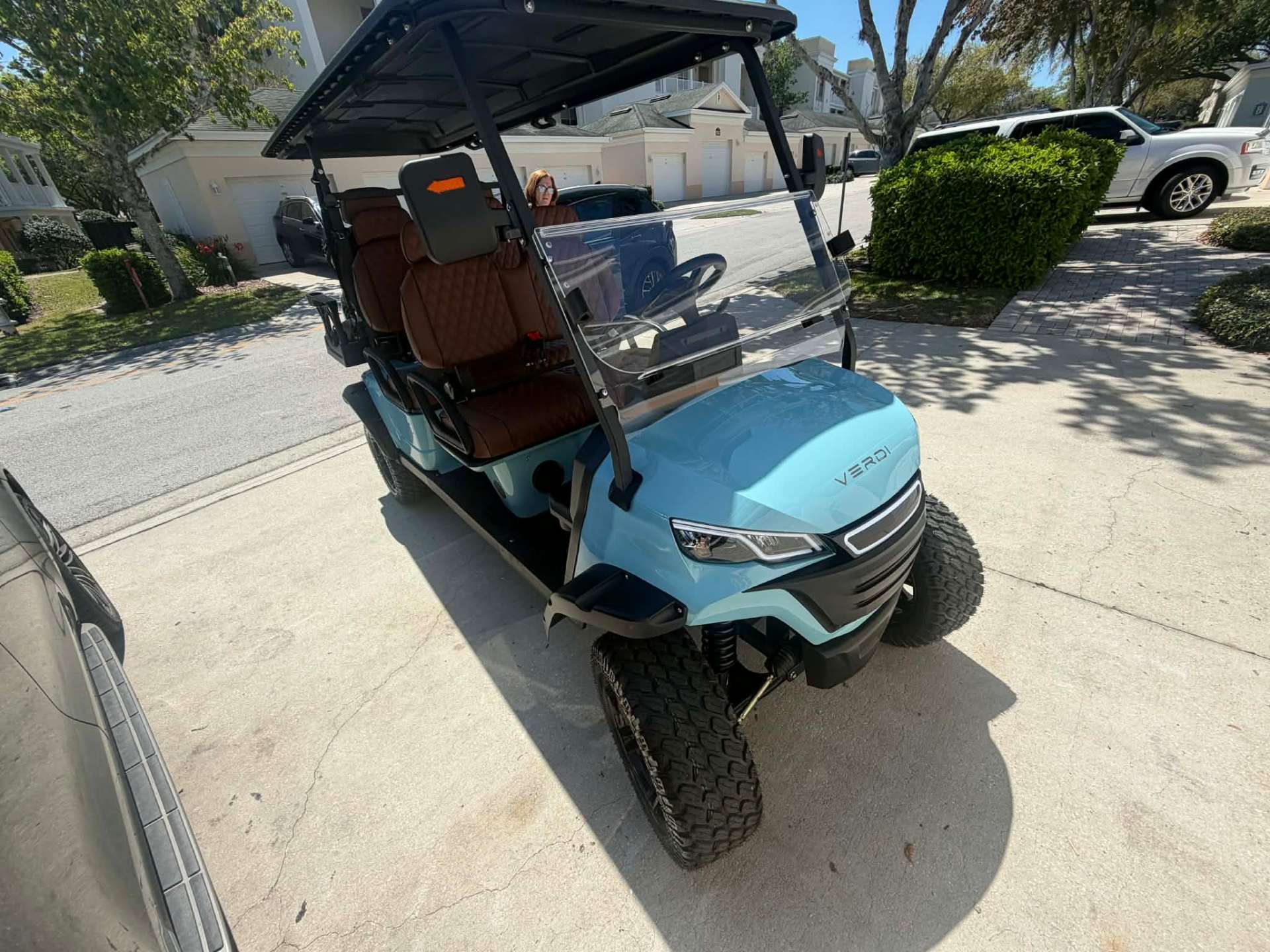 Teal Verdi lifted golf cart parked in a ChampionsGate community driveway