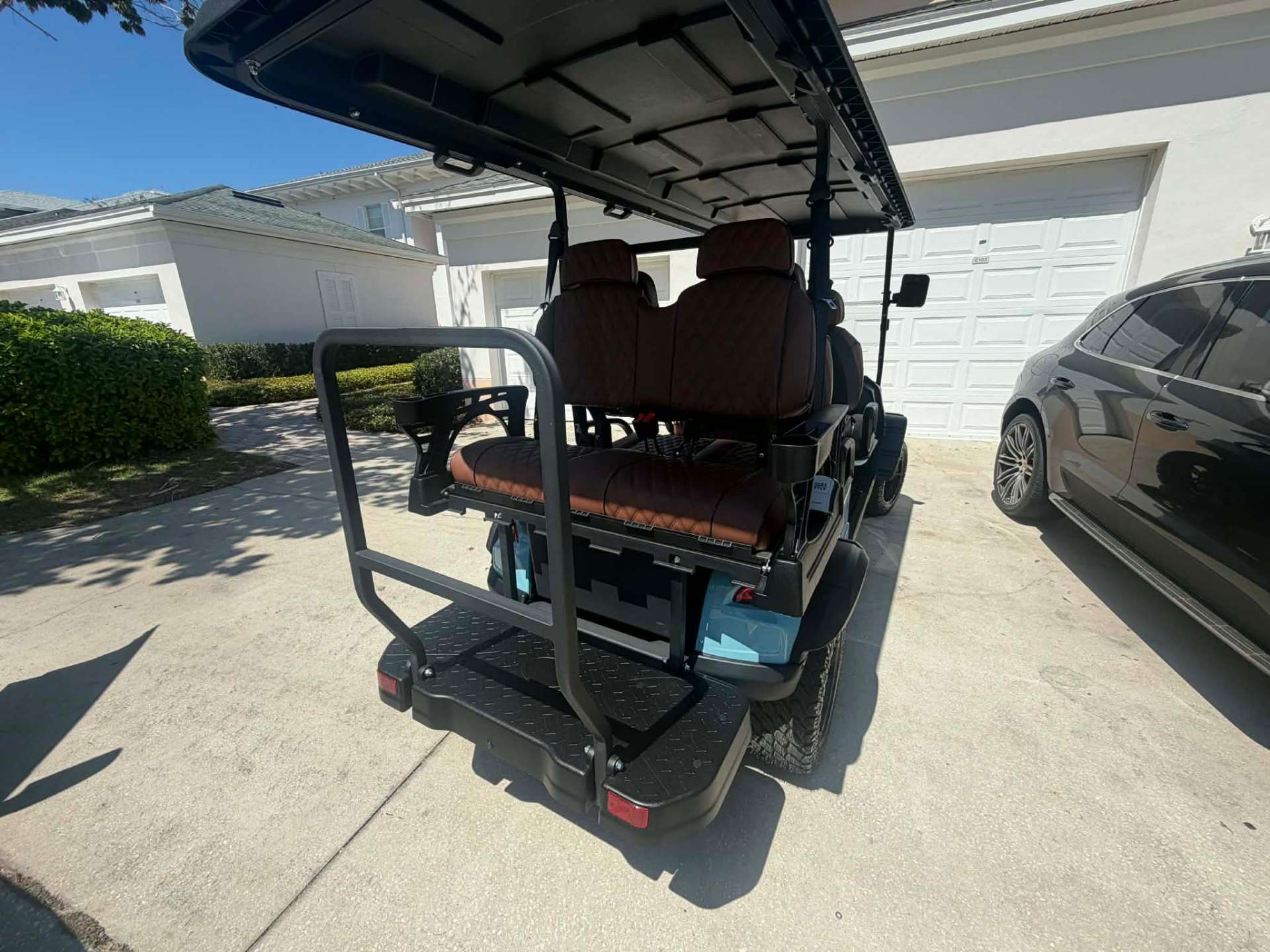 Rear view of teal 6-seater golf cart with rear-facing bench seat